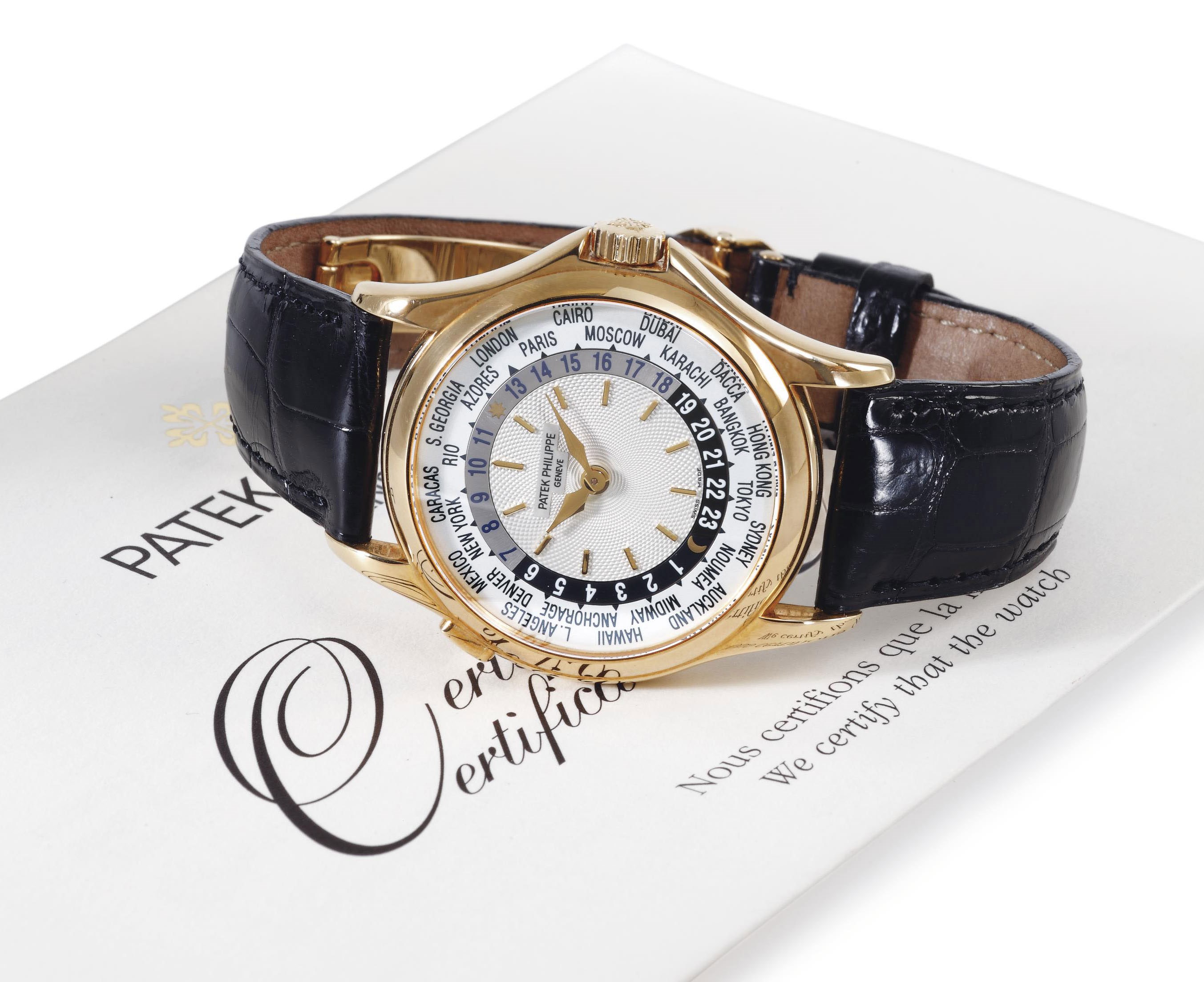 PATEK PHILIPPE. AN 18K GOLD AUTOMATIC WORLD TIME WRISTWATCH