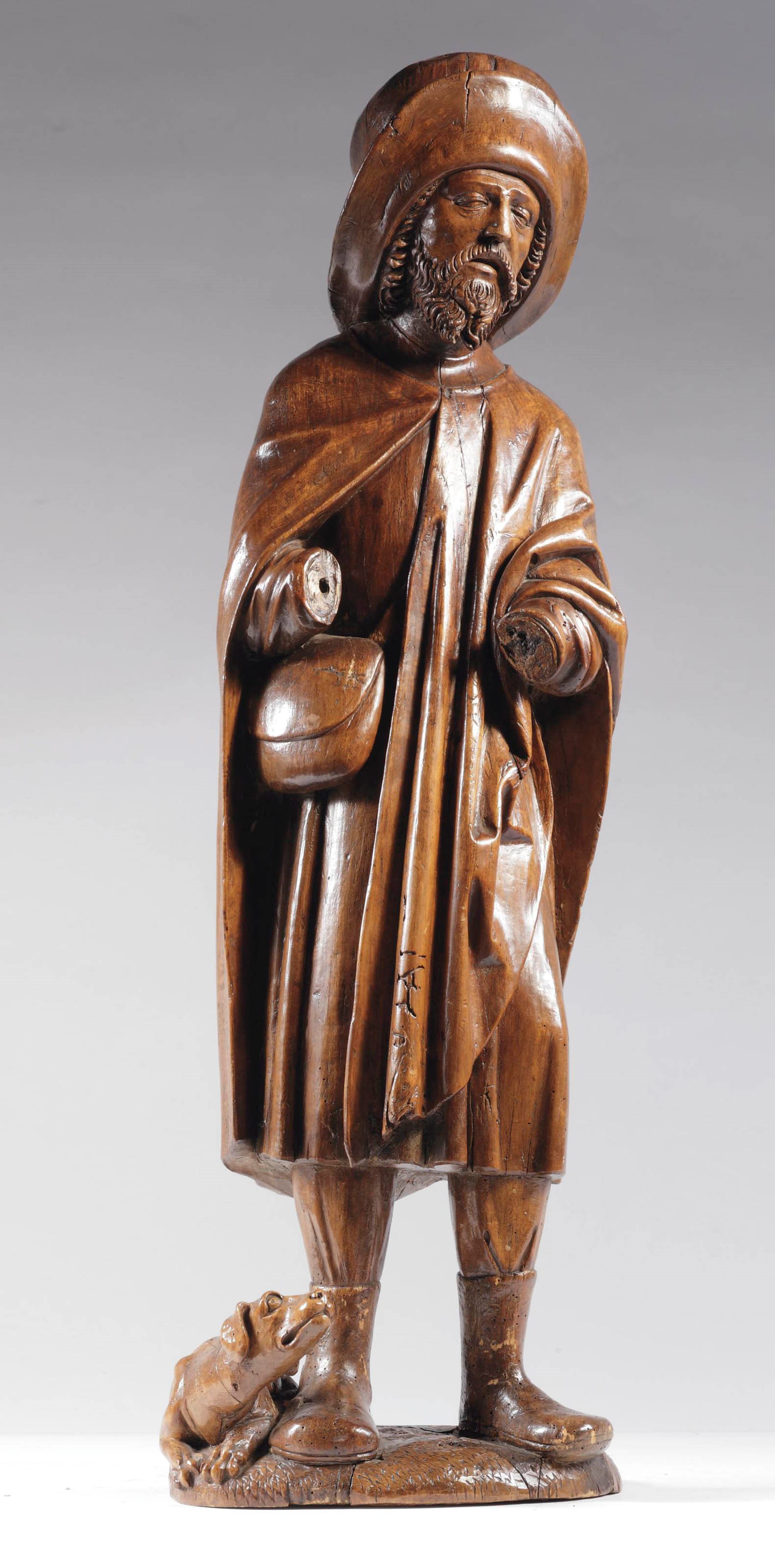 A CARVED WALNUT FIGURE OF SAINT ROCHE