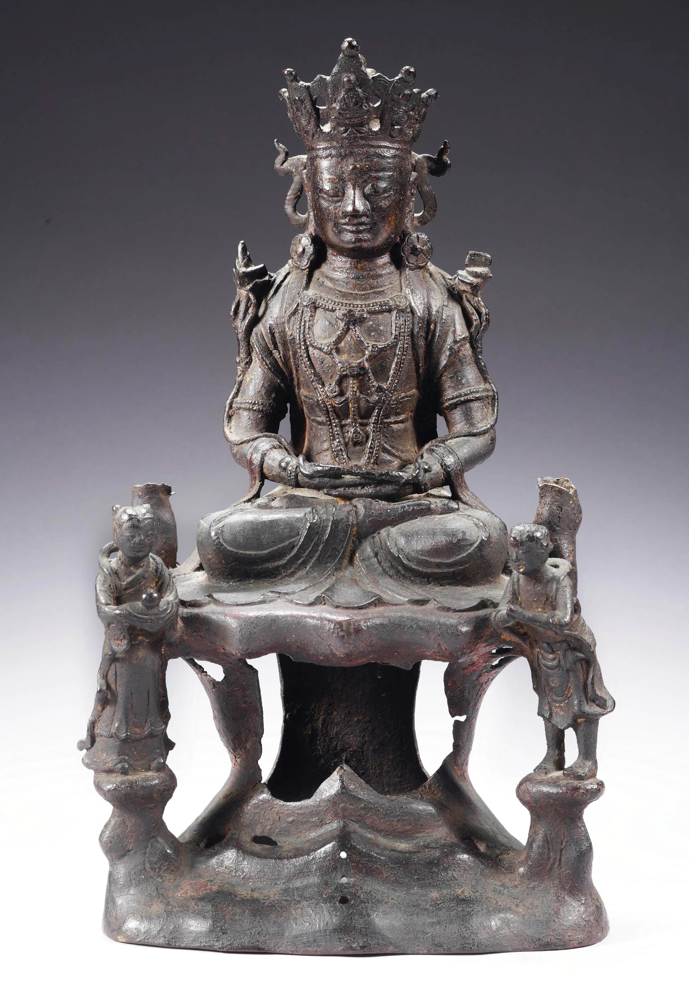 A Chinese bronze figure of Guanyin with two worshippers