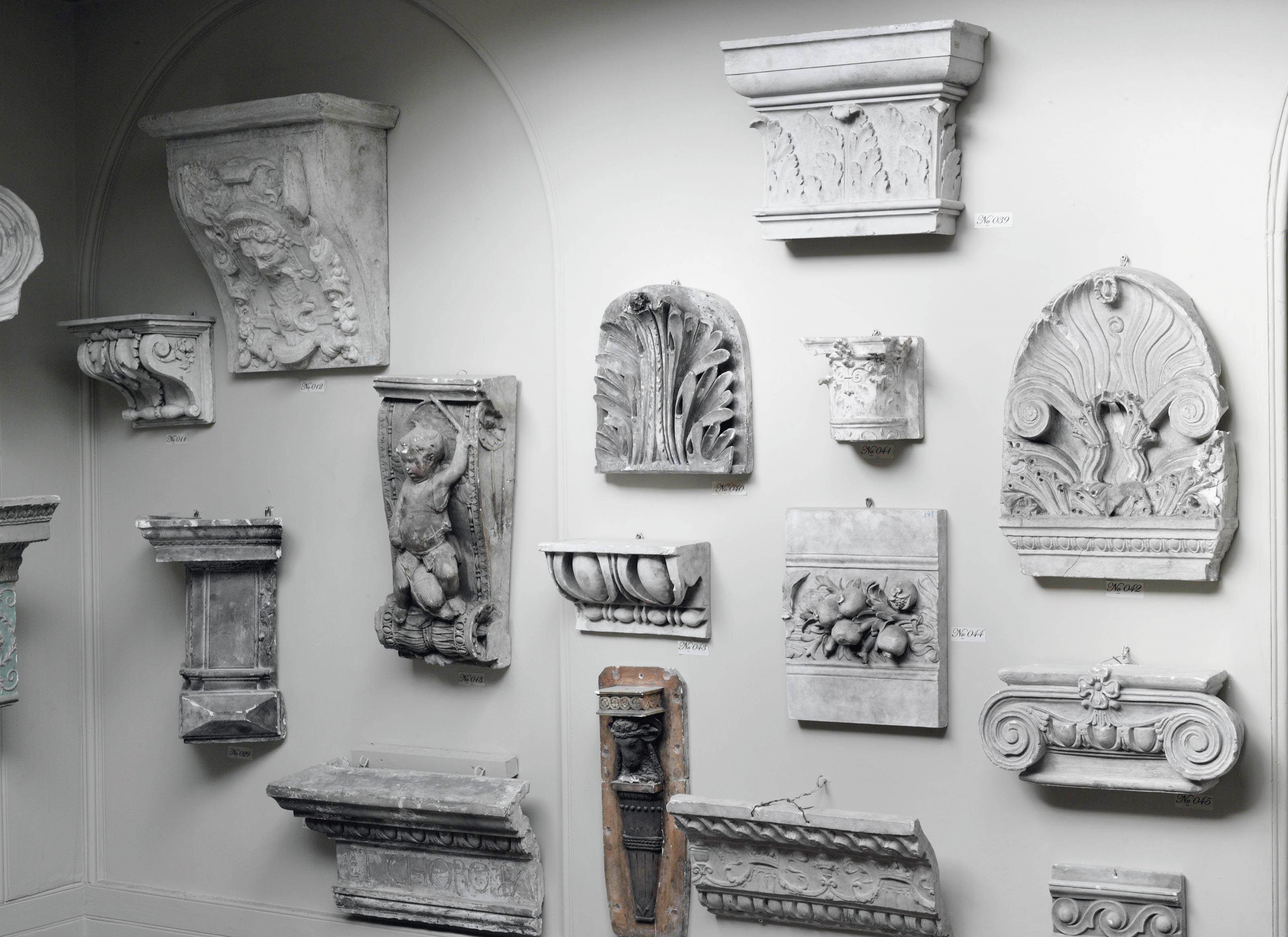 A COLLECTION OF FIFTEEN PLASTER CAPITALS, CORBELS AND ARCHITECTURAL FRAGMENTS