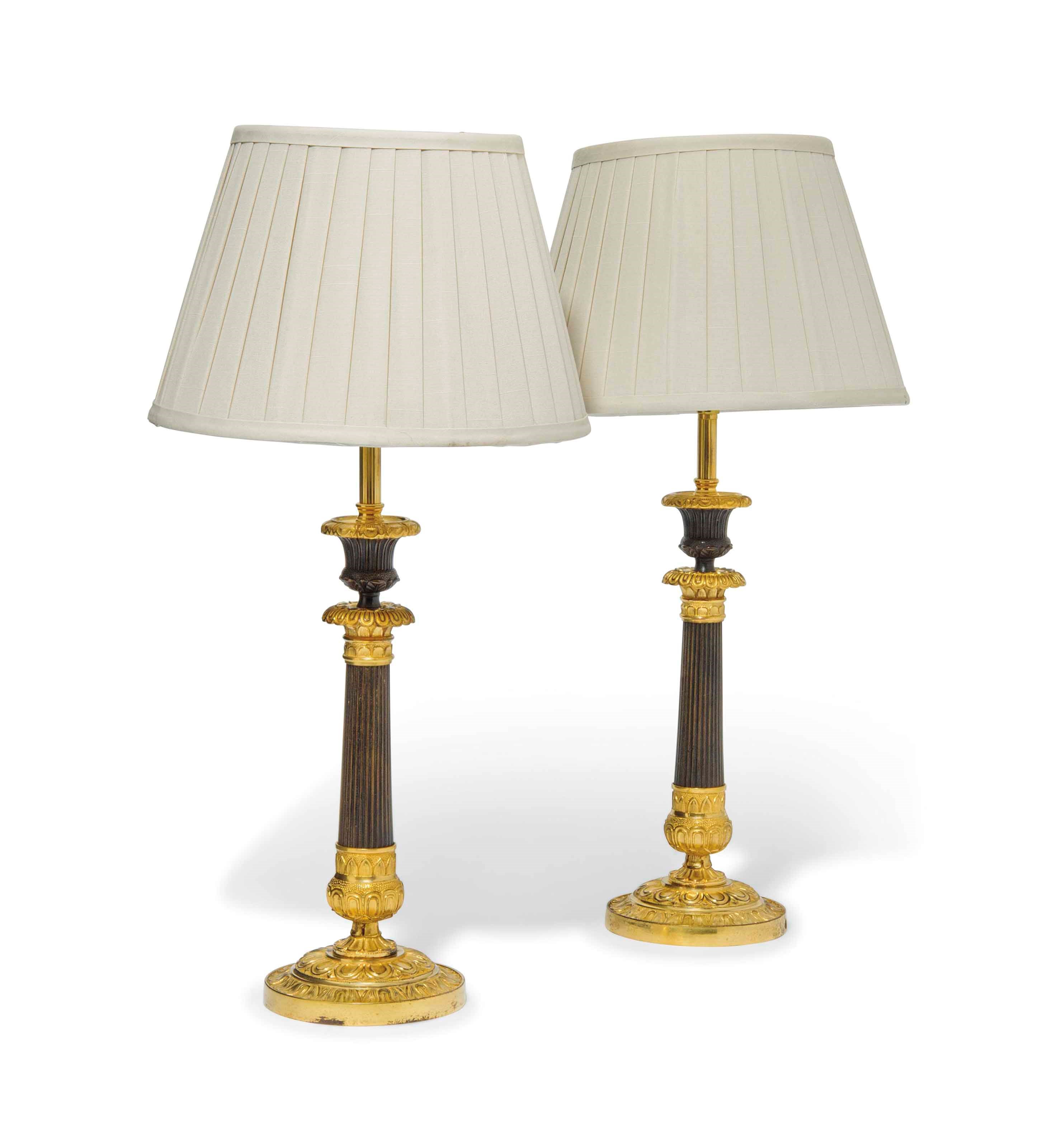 A PAIR OF GILT AND PATINATED BRONZE CANDLESTICKS AS LAMPS