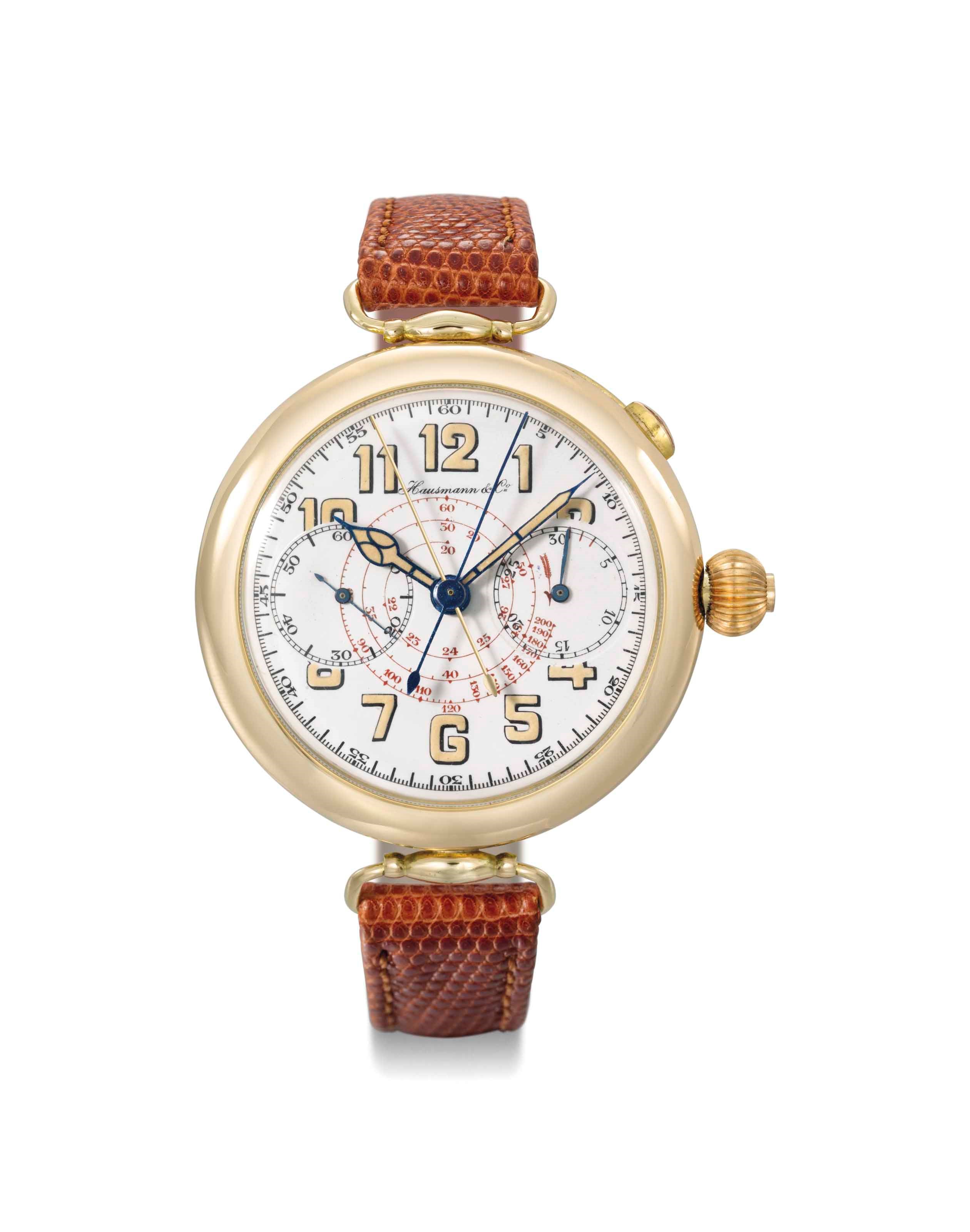 Hausmann. A large and attractive 18K gold single button split seconds chronograph wristwatch with enamel dial