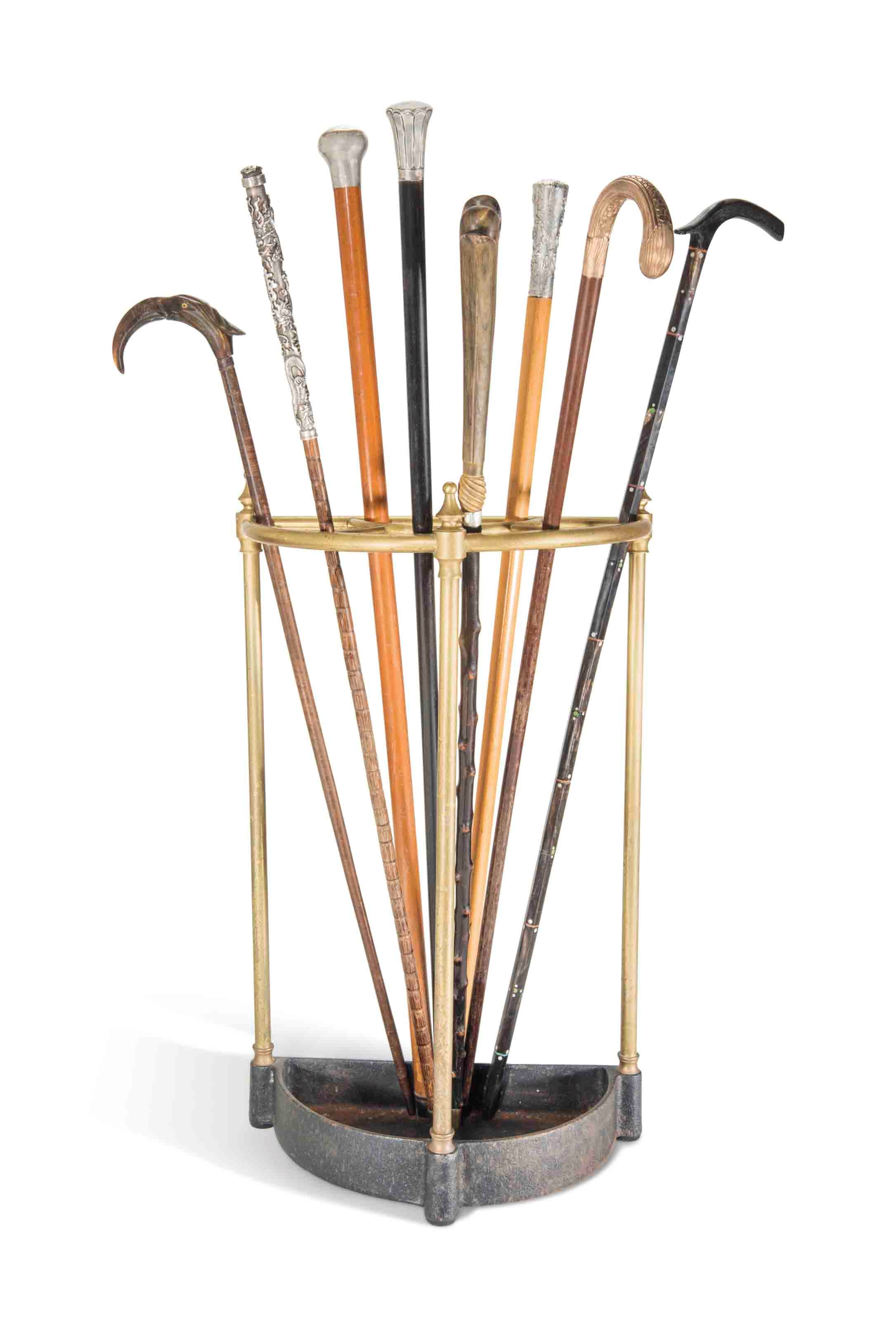 A GROUP OF EIGHT WALKING STICKS AND A BRASS STICK STAND