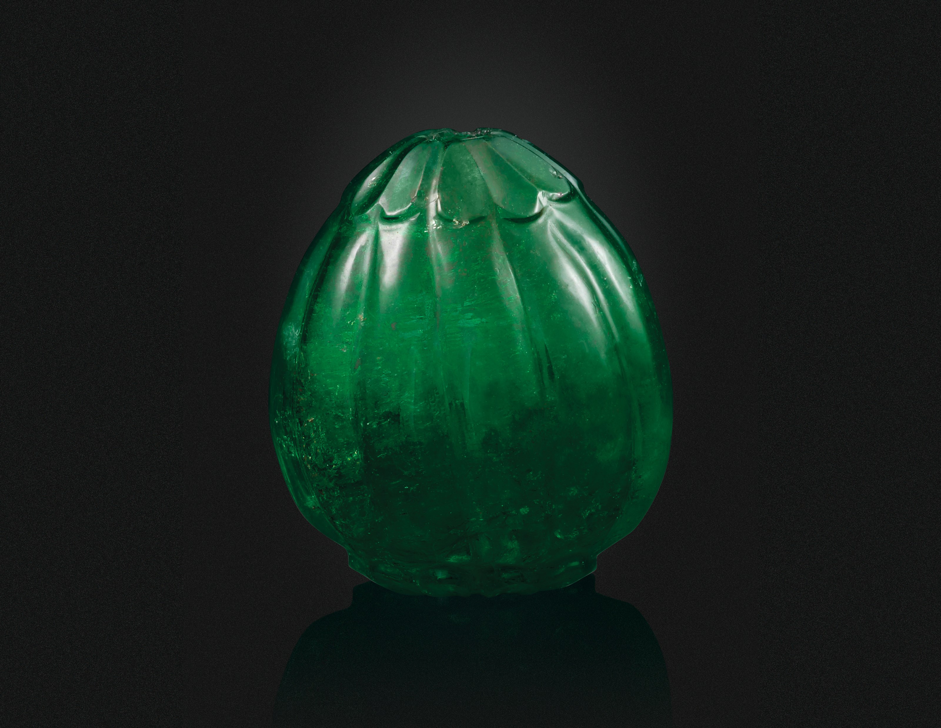 A CARVED EMERALD BEAD