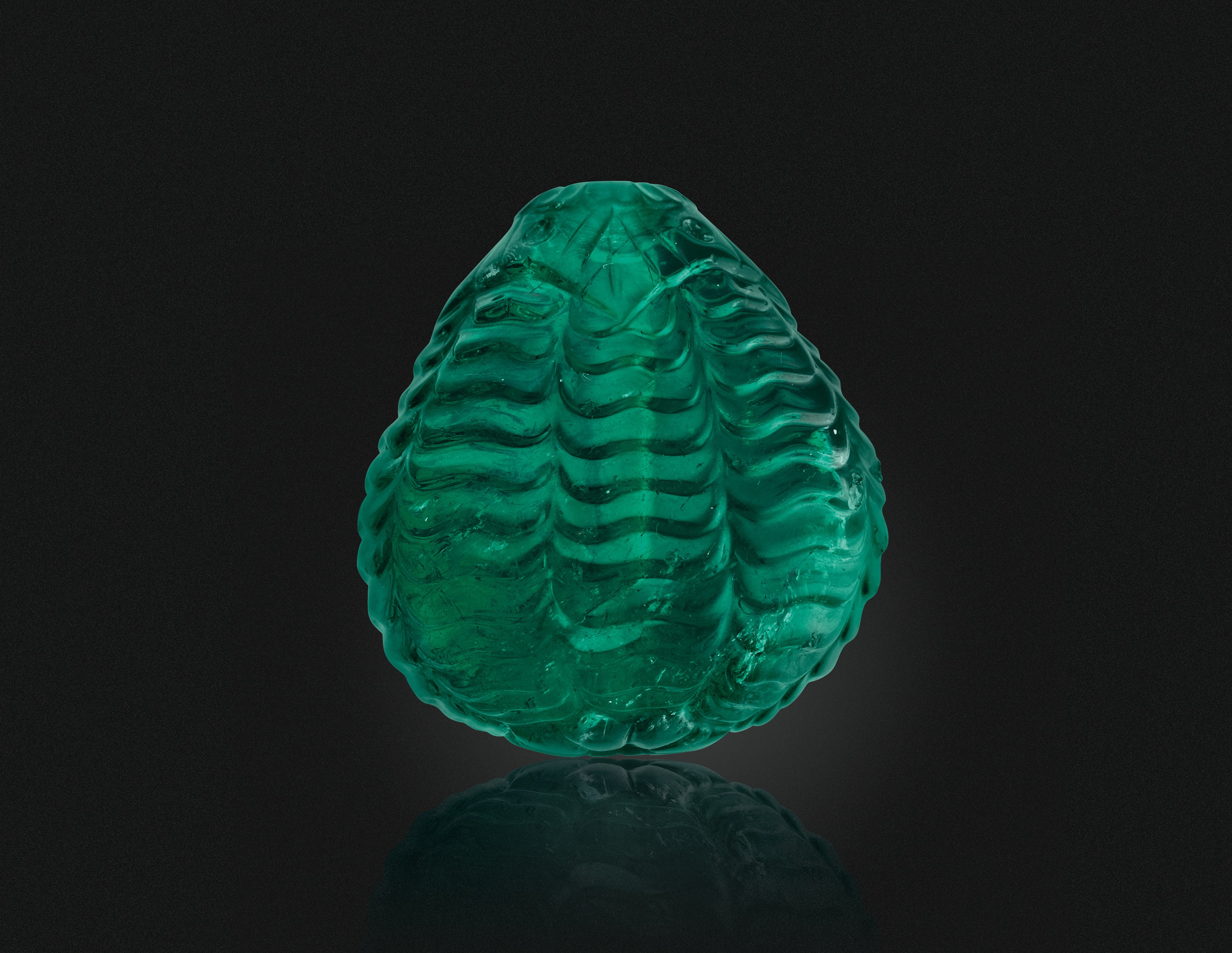 A CARVED EMERALD BEAD